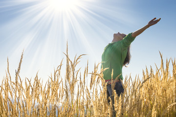 Happy young girl raising her arms with bliss and joy