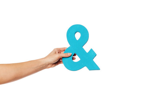 hand holding up an ampersand from the left