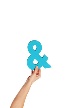 hand holding up an ampersand from the bottom