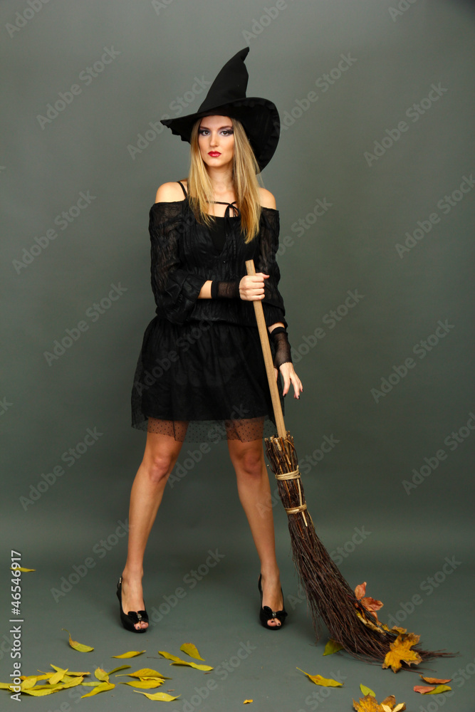 Halloween witch with  broom on gray background