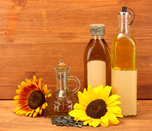 Oil In Bottles, Sunflowers And Seeds, On Wooden Background