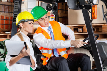 Wall Mural - Male Supervisor Showing Something To Colleague At Warehouse