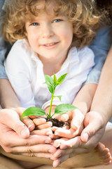 Poster - Family holding young plant