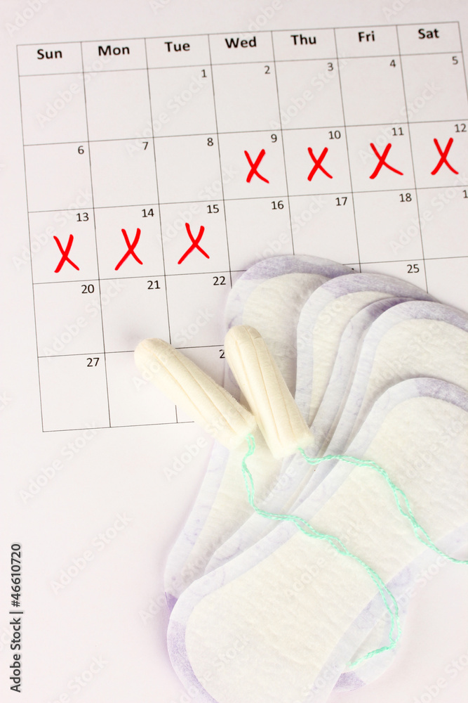 menstruation calendar with sanitary pads and tampons, close-up