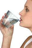 Fototapeta Łazienka - Young woman drinking a glass of water