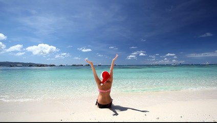 Wall Mural - Happy woman in Santa Hat on tropical beach