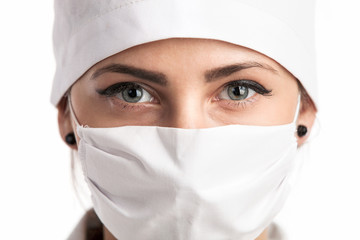 Closeup of a young female doctor wearing a mask and a hat