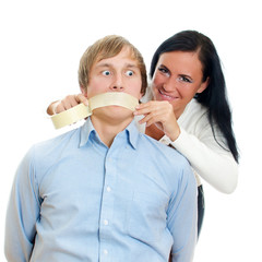 Woman applying tape on man's mouth. Isolated on white.