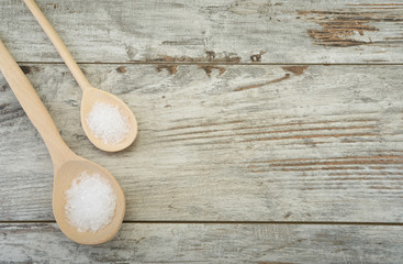 Two spoons of sea salt on table with space for your text