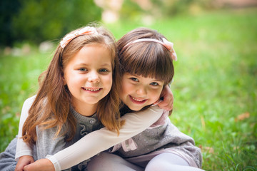 happy little girlfriends in park