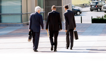 Three businessmen walking on the street.