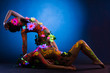 Nude women with glow uv body art and flowers 