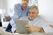 © goodluz - Modern senior couple websurfing on tablet