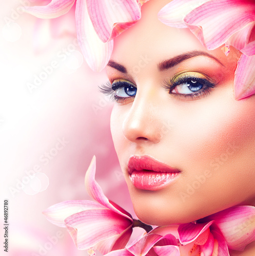 Naklejka ścienna Beautiful Girl With Orchid Flowers. Beauty Woman Face