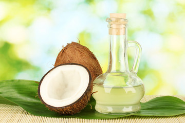 Wall Mural - decanter with coconut oil and coconuts on green background