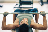 Young man lifting the barbell in the gym.