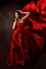 Woman in red dress  with flying fabric