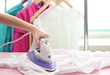 © Africa Studio - Woman hand ironing a shirt, on cloth background