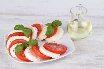 Sticker - Tomato and mozzarella with basil leaves on a white plate