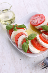 Sticker - Tomato and mozzarella with basil leaves on a white plate