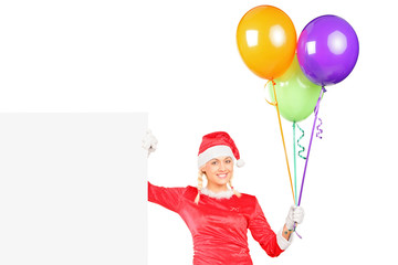 Poster - Sexy female in santa costume holding balloons next to a billboar