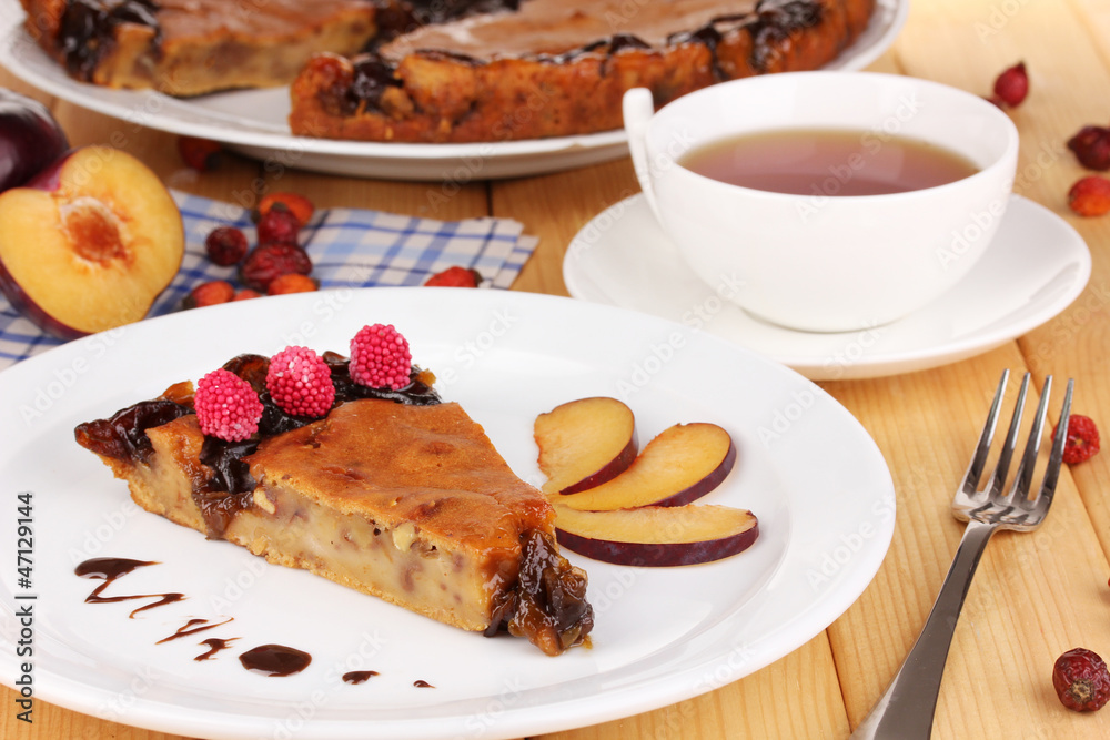 Tasty pie on plate on wooden table