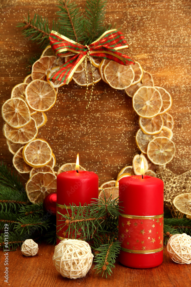 Two candles and christmas decorations, on golden background