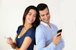 © goodluz - Couple standing back to back and using smartphone
