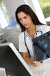 © goodluz - Young medical woman checking xray results