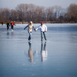 © lightpoet - Couple ice skating outdoors on a pond