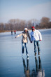© lightpoet - Couple ice skating outdoors on a pond on a lovely sunny winter d