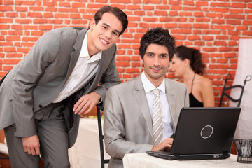 men using a laptop in a restaurant