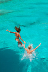 Two girls jumping in the sea