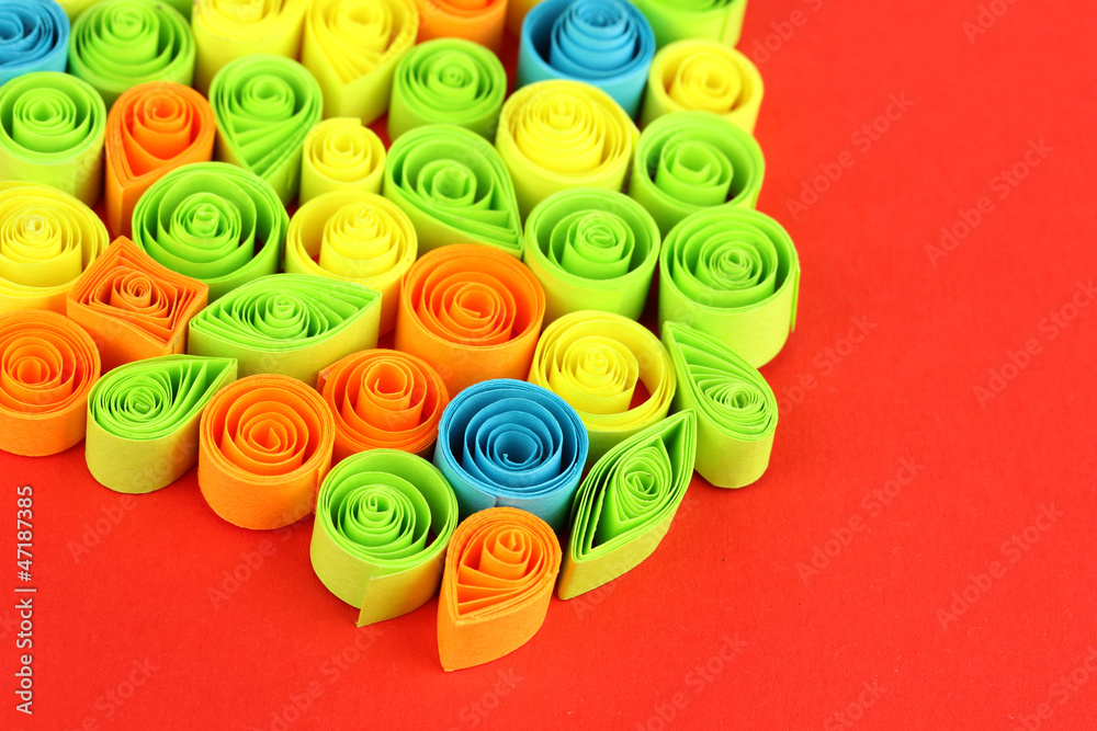 Colorful quilling on red background close-up