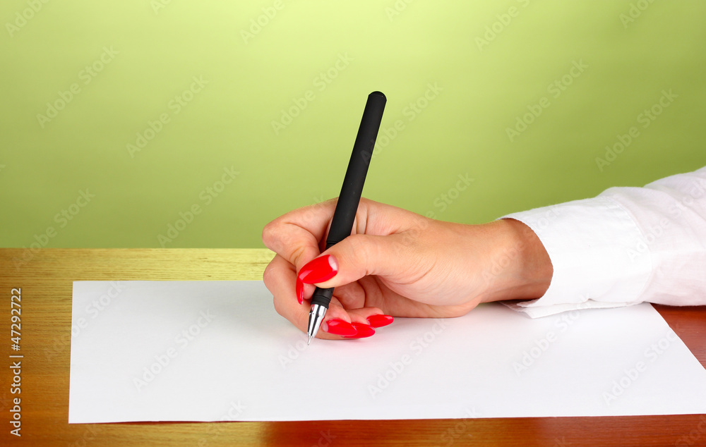 Hands writing on  paper on green background