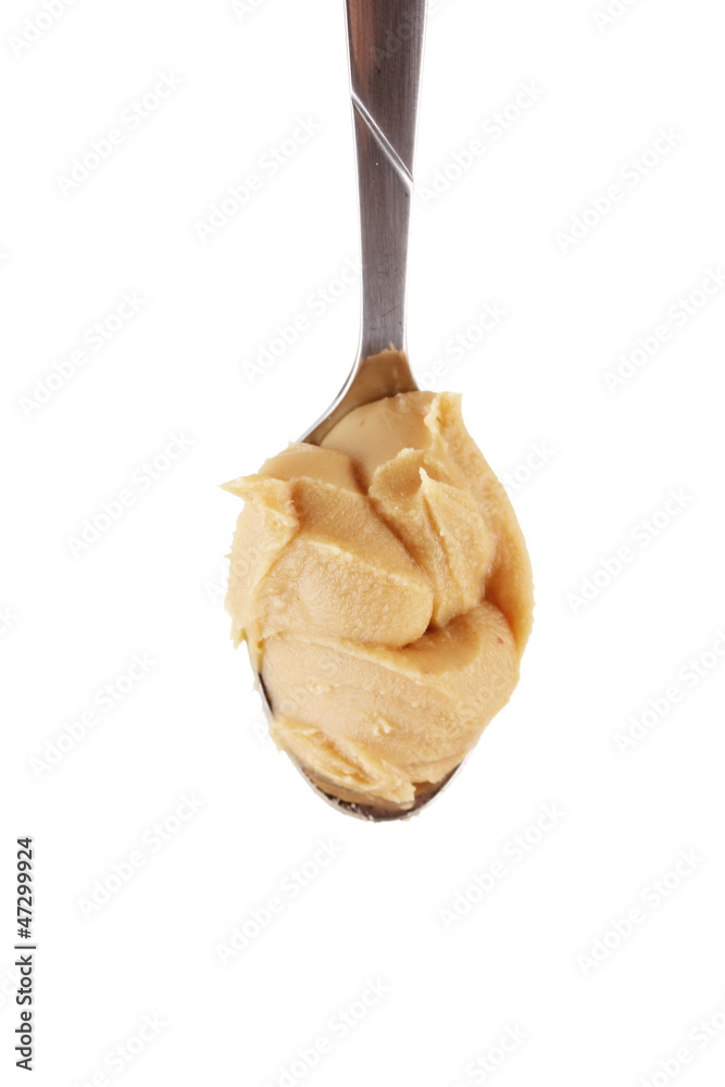 Delicious peanut butter in spoon isolated on white close-up