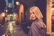 Beautiful blond woman in raincoat walking alone