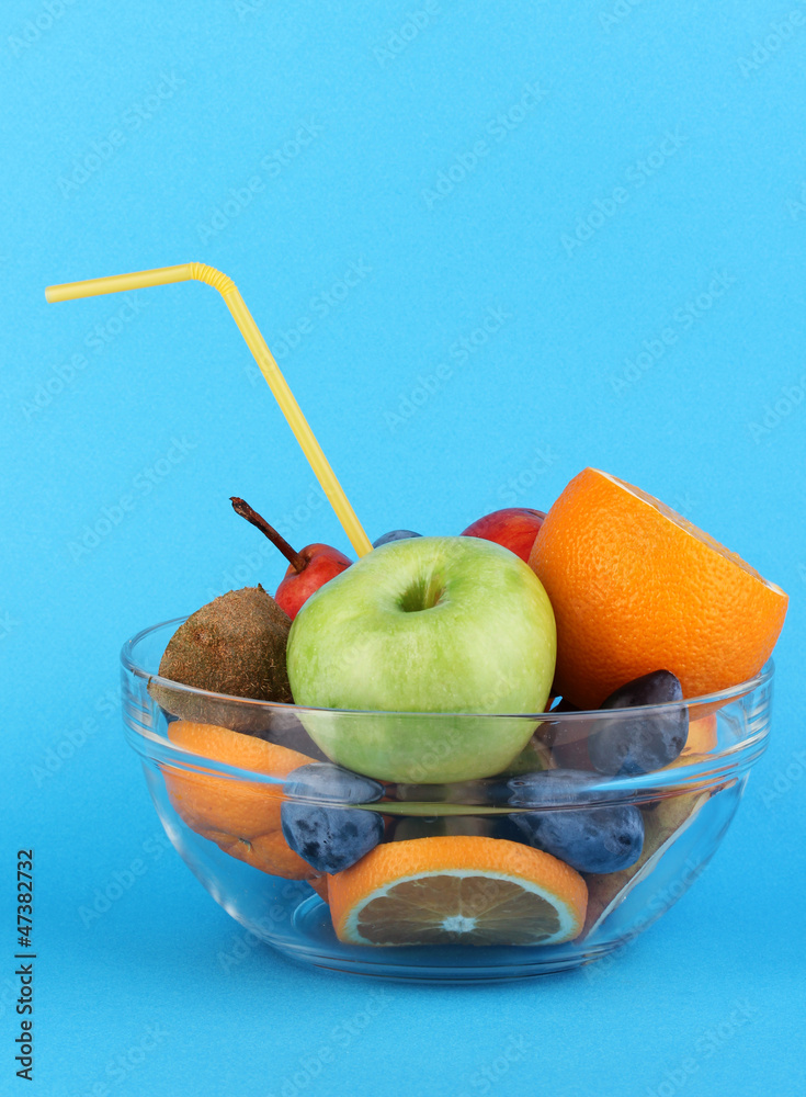 Glass bowl with fruit for diet on blue background