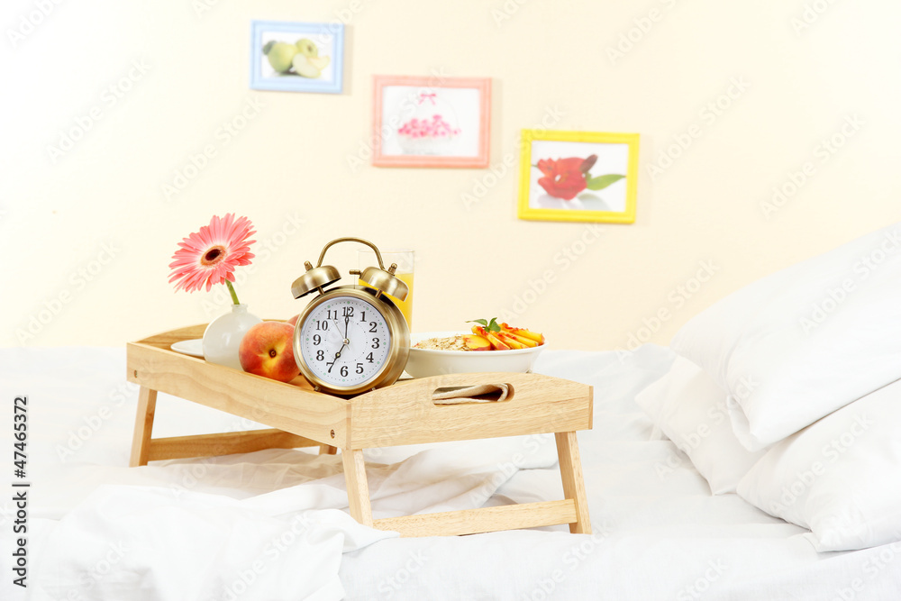 wooden tray with light breakfast on bed