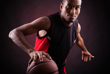 Portrait of a young male basketball player against black backgr