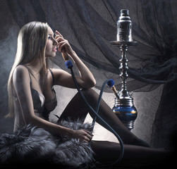 Wall Mural - A young blond woman in lingerie smoking a hookah