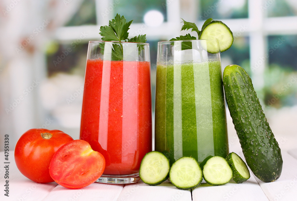 Fresh vegetable juices on wooden table, on window background