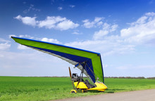 Motorized Hang Glider Over Green Grass