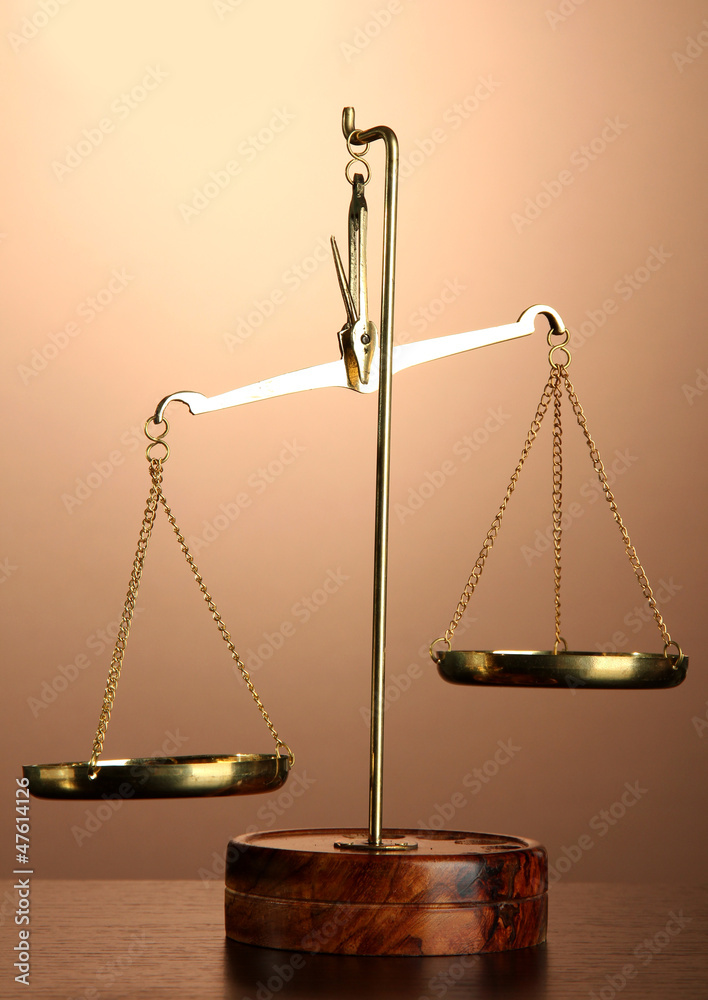 Gold scales of justice on brown background