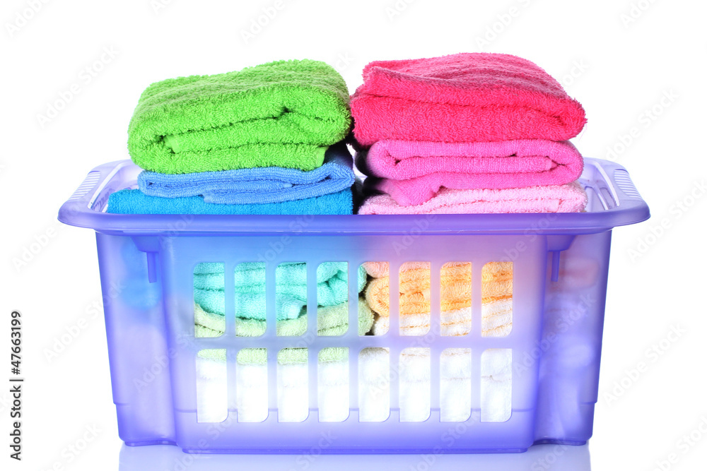Plastic basket with bright towels isolated on white