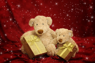 Two teddy bears with golden gift box on red stars background