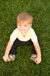 © Elegant Solution - Smiling little boy sitting in fresh grass