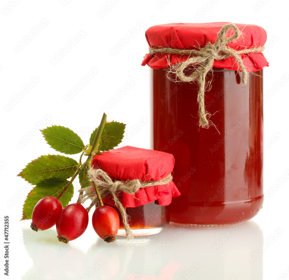 jars with hip roses jam and ripe berries, isolated on white