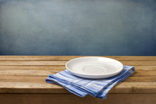 Empty Plate On Tablecloth On Wooden Table