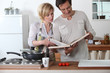 © auremar - Couple cooking together with a recipe book
